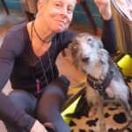 Relaxed owner sitting beside their happy and settled adolescent dog